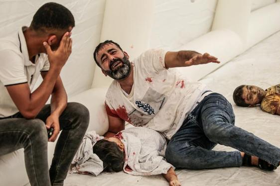 Un hombre muestra su dolor por la muerte de su hijo durante uno de los bombardeos de esta noche sobre Gaza.