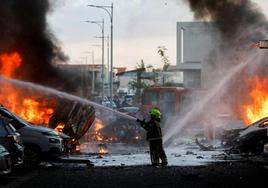 Un bombero trata de apagar el fuego tras el ataque.