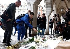 Un grupo de personas deposita flores en recuerdo de Dominique Bernard en Arras.