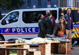 Varias personas depositan flores en el lugar de Arras donde un islamista radical asesinó a un profesor el pasado día 13.