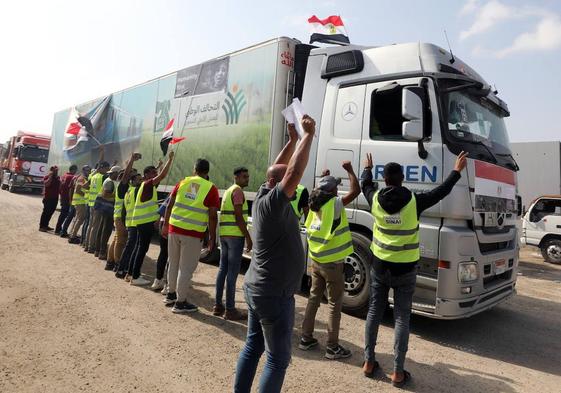 Ciudadanos egipcios saludan al conductor de uno de los camiones que han entrado este domingo en Gaza.