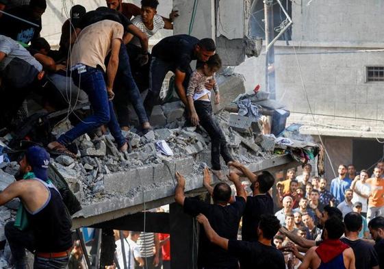 Palestinos rescatan a una niña herida entre las ruinas de un edificio bombardeado por Israel en Gaza.