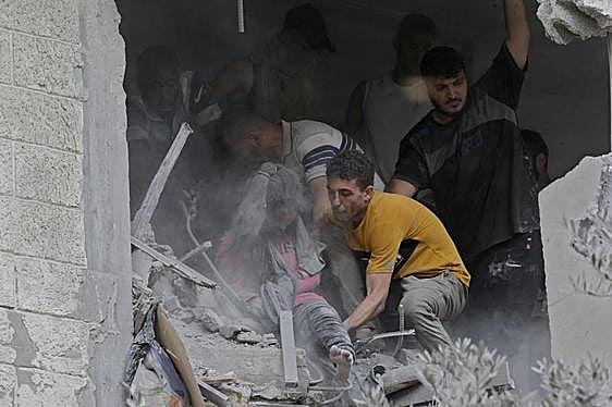 Palestinos recuperan un cuerpo entre los escombros de una vivienda destruida en la Franja.