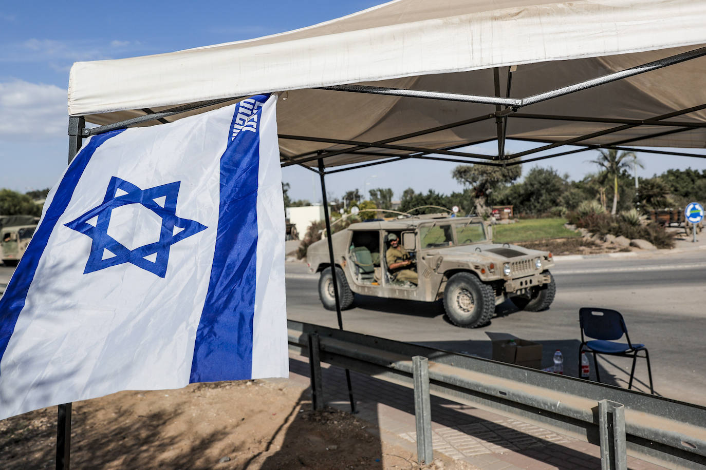 Un vehículo blindado y soldados del ejercito israelí se encuentran agrupados en una zona del frente