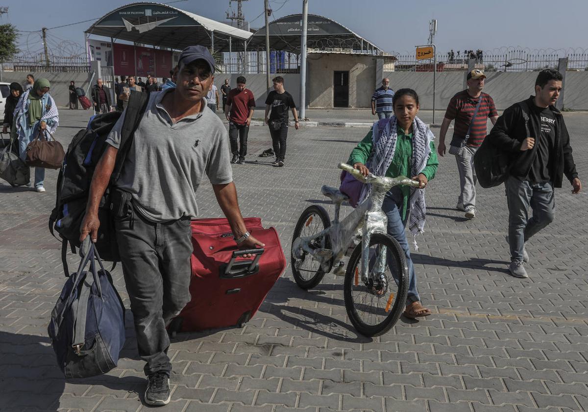 Cientos de palestinos con doble nacionalidad cruzan la frontera entre Gaza y Egipto por el paso de Rafah.