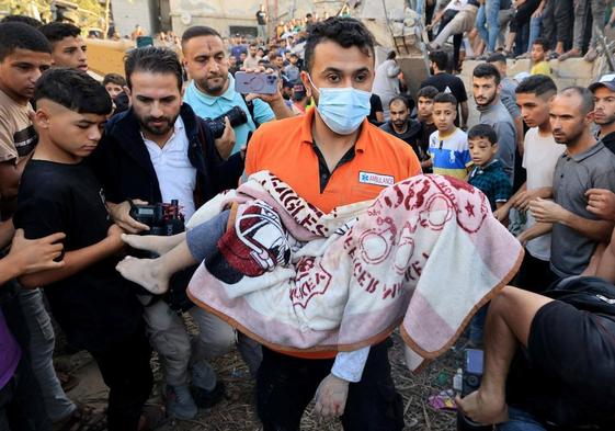 Un hombre sostiene el cadáver de un niño en Gaza.