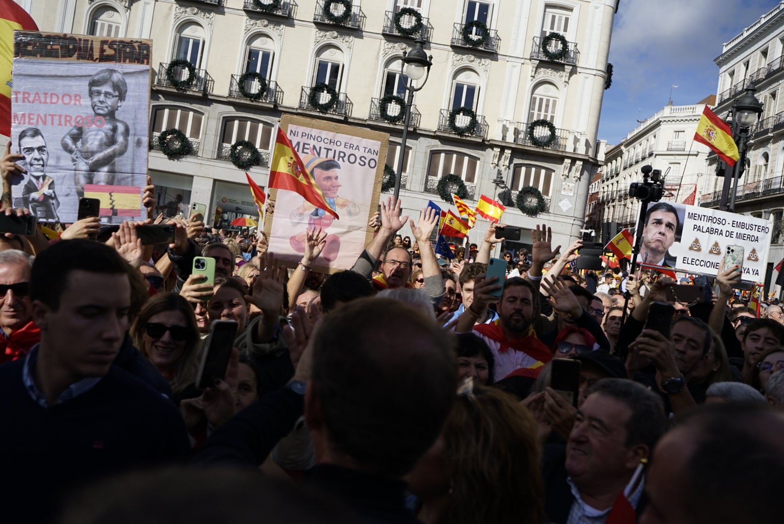 Feijóo saluda a los manifestantes en la Puerta del Sol.