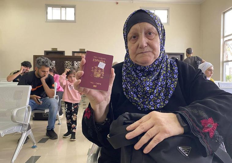 Una de las evacuadas muestra su pasaporte español.