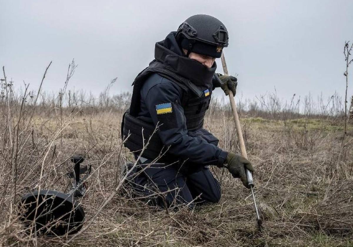 Un miembro del Servicio Estatal de Emergencias inspeccionan una zona en busca de minas y proyectiles sin detonar en Járkov, en Ucrania