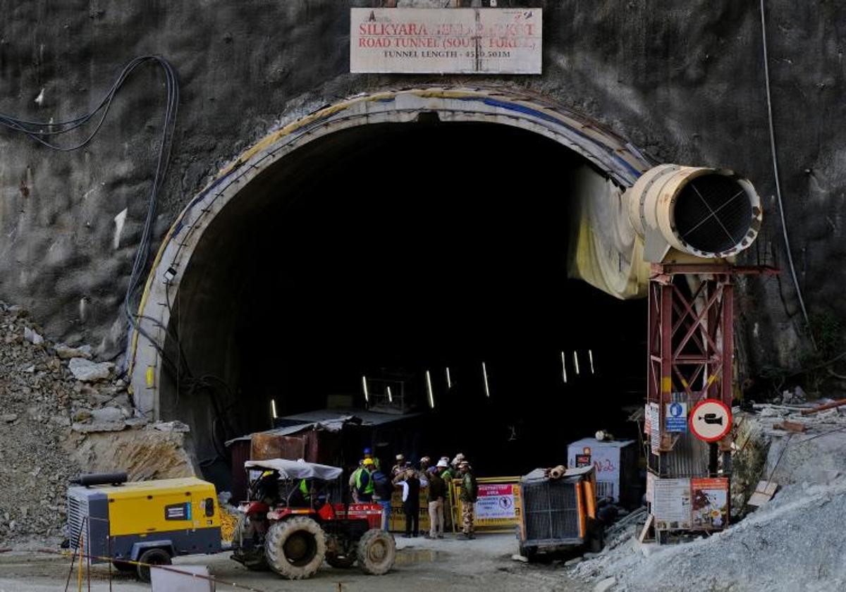 Miembros de los equipos de rescate y personal de seguridad trabajan junto al túnel colapsado.