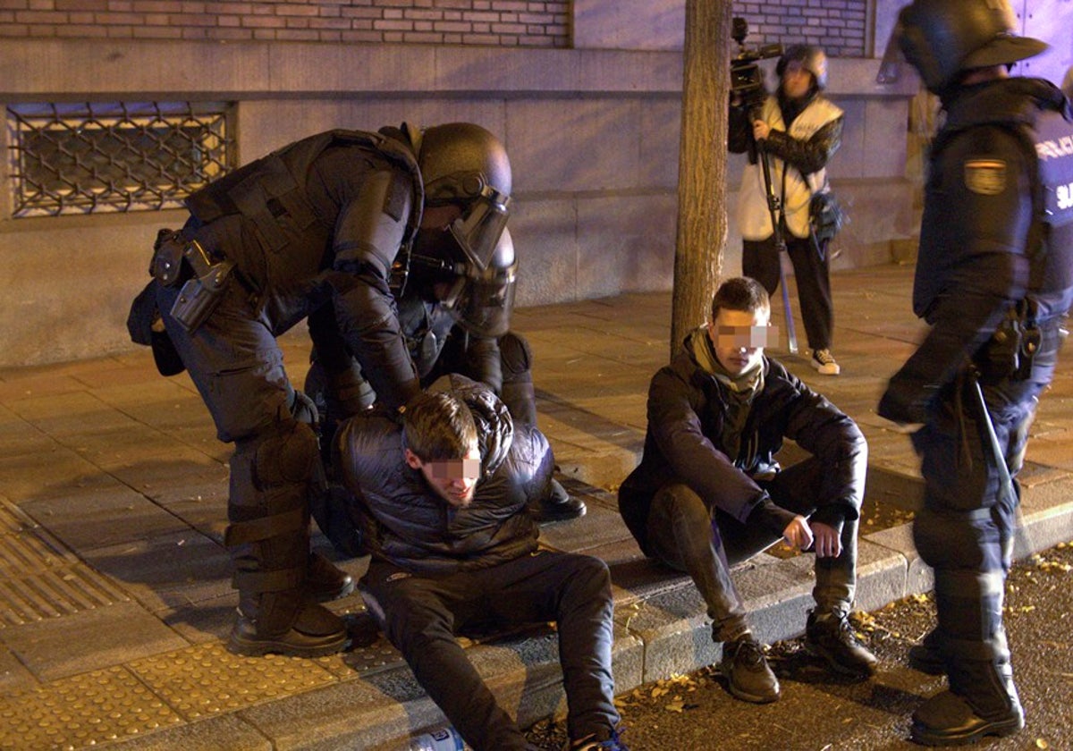 Efectivos de la UIP de la Policía detienen ayer a dos manifestantes cerca de la sede del PSOE en la calle Ferraz (Madrid).