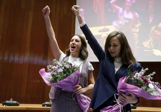 Irene Montero e Ione Belarra levantan el puño tras el acto de traspaso de carteras ministeriales en el Ministerio de Derechos Sociales.