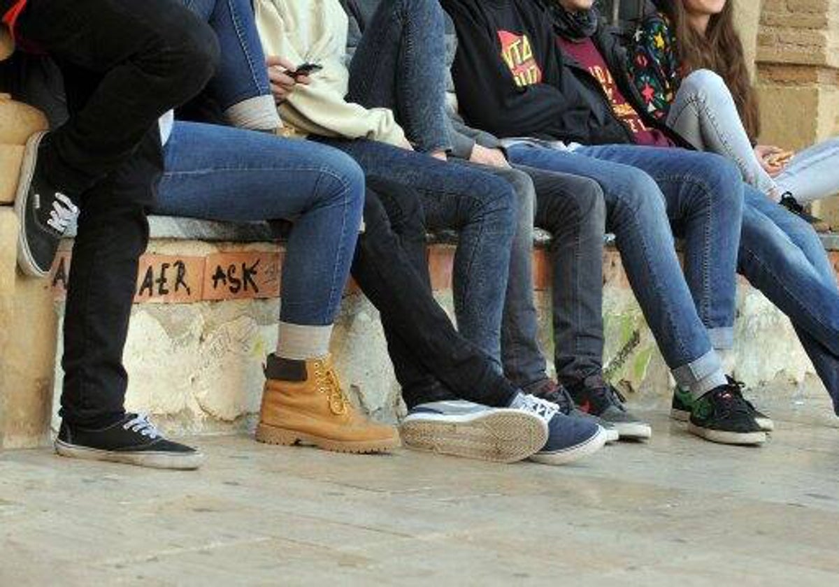 Un grupo de jóvenes sentados en una calle.