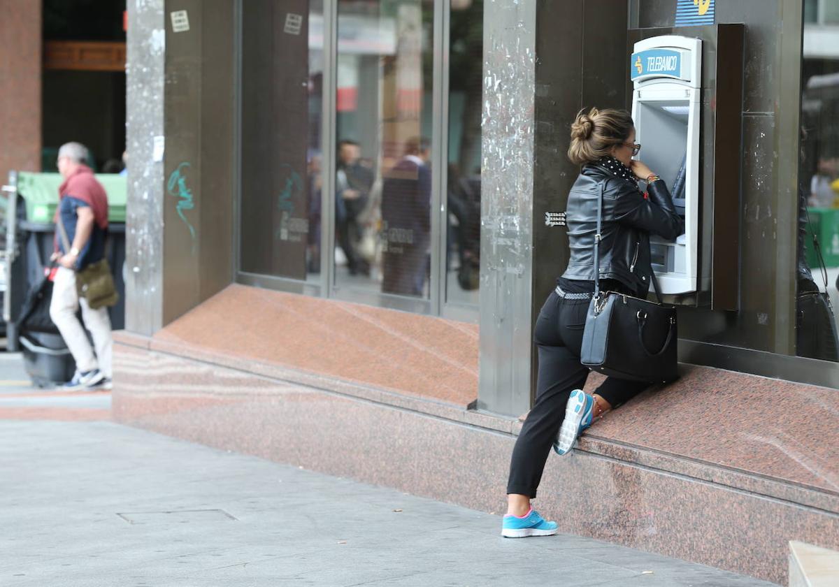 Una mujer saca dinero en un cajero de Bilbao.