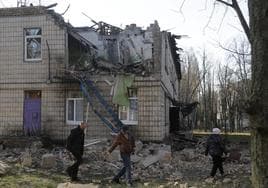 Residentes de Kiev observan los destrozos en una guardería por los ataques con drones.