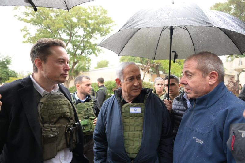 Elon Musk y Benjamín Netanyahu, con un representante local del kibutz Kfar Aza.