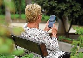 Una anciana navega con su móvil en internet.