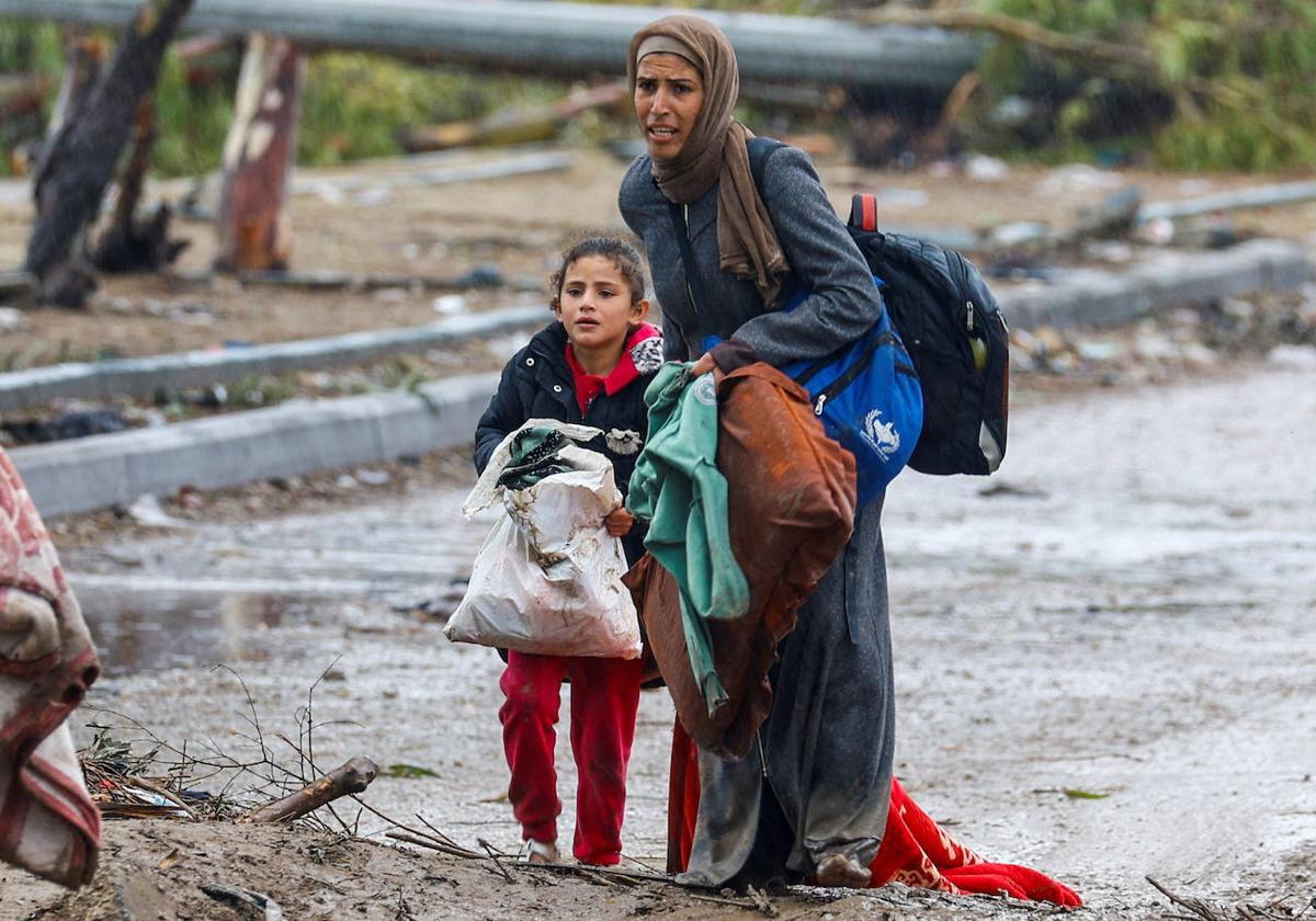 Una mujer y su hija caminan por las calles de un barrio arrasado en el norte de Gaza.