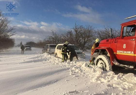 Miembros de los servicios de emergencia de Ucrania retiran nieve de una carretera en la región de Mykolaiv.