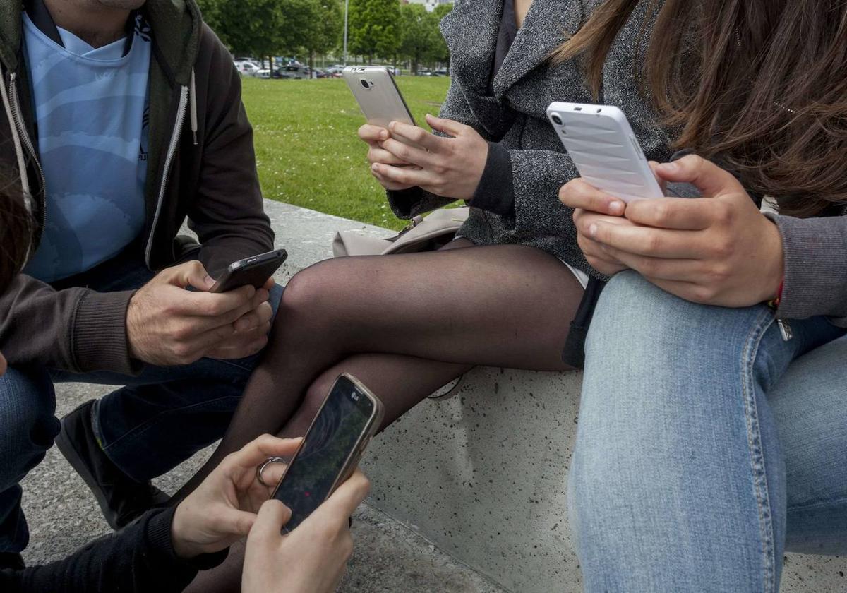 Jóvenes con sus teléfonos móviles.