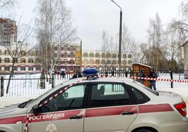 Varios policías rusos esperan en la entrada del colegio de Briansk donde se ha producido el tiroteo.