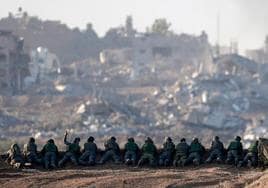 Soldados israelíes apostados en una colina en el norte de Gaza desde donde observan una zona reducida a escombros.