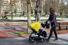 Una mujer paseando a un bebe.
