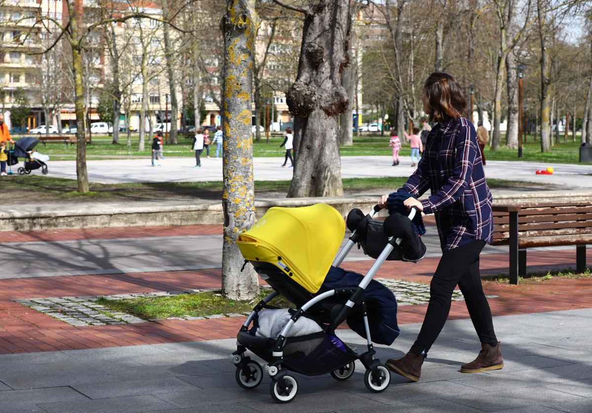 Una mujer paseando a un bebe.