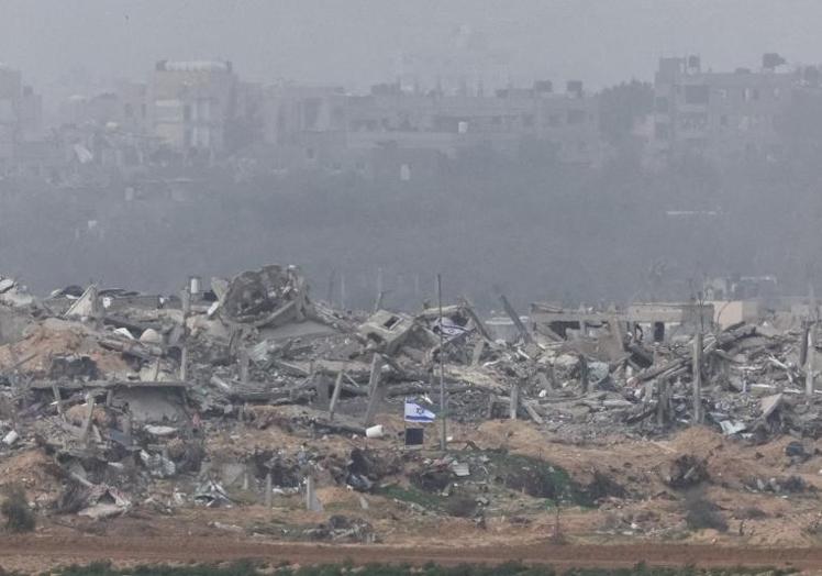 Banderas israelíes ondean junto a los escombros de edificios destruidos en Gaza.