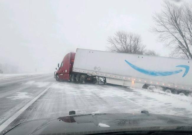 Un camión se sale de la carretera nevada por las díficiles condiciones para conducir.