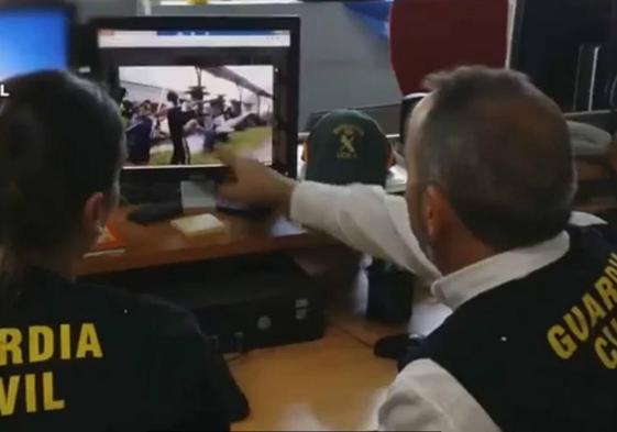 Agentes de la Guardia Civil examinan un vídeo en el que aparecen mensajes e imágenes enviados por jovenes que hacen apologia del terrorismo en internet.