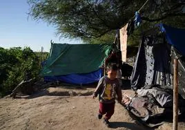 Un niño pasa frente a un campamento de migrantes en Matamoros, en el norte de México.