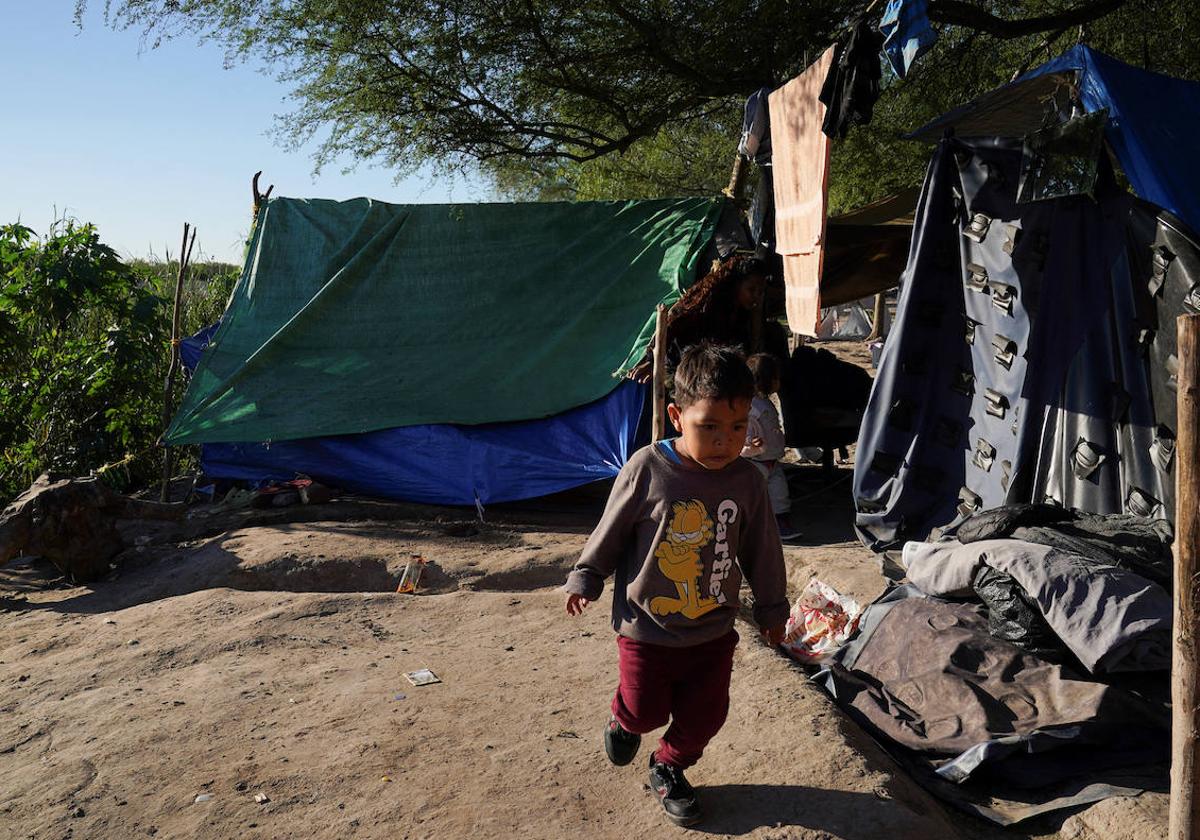 Un niño pasa frente a un campamento de migrantes en Matamoros, en el norte de México.