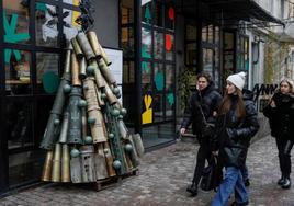 La gente pasa junto a un árbol de Navidad hecho con proyectiles de artillería en Kiev