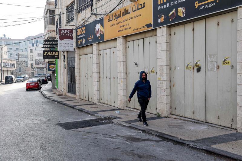 Un hombre camina por una solitaria calle de Ramala después de que la Autoridad Palestina haya declarado una huelga general por el asesinato del vicepresidente político de Hamás.