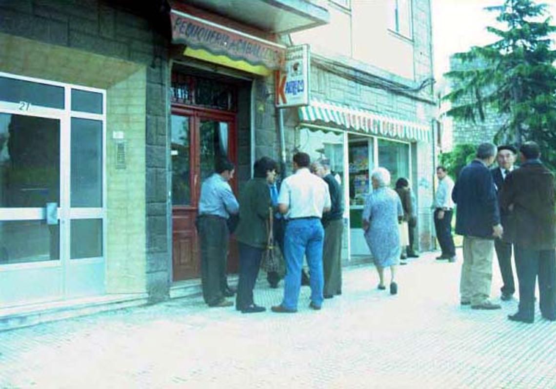 Vecinos frente a la peluquería que regentaba Alfredo en el barrio avilesino de Buenavista