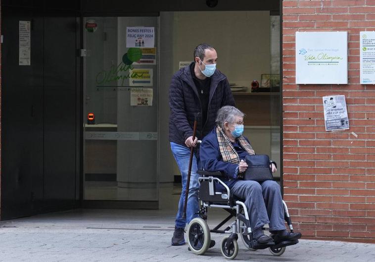 Un paciente y su acompañante salen con la mascarilla puesta de un centro sanitario de Barcelona.