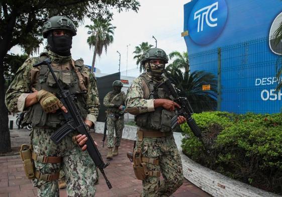 Miembros de las fuerzas de seguridad vigilan frente a la televisión local TC de Guayaquil durante la visita del presidente de Ecuador, Daniel Noboa.