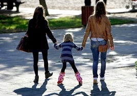 Dos mujeres acompañan a un parque de Valencia a una niña para que juegue un rato.