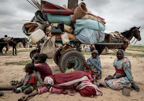Una familia sudanesa huye con sus escasas pertenencias del conflicto en Darfur.