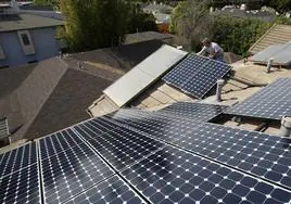 Instalación de paneles solares en los tejados de las viviendas de una zona residencial.