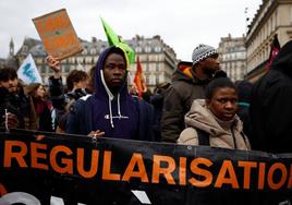 Decenas de personas participan en una protesta contra la reforma migratoria en París.
