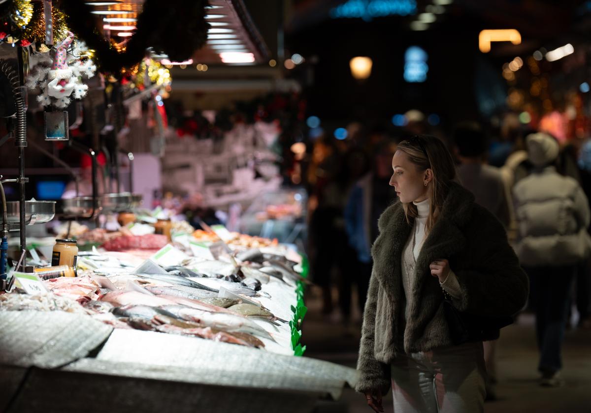 Una mujer mira el género en una pescadería