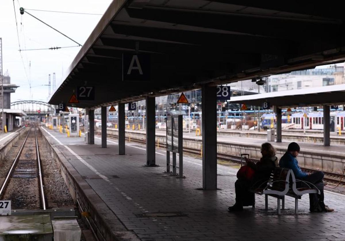 Dos pasajeros esperan en la estación central de trenes de Múnich, desierta por la huelga.