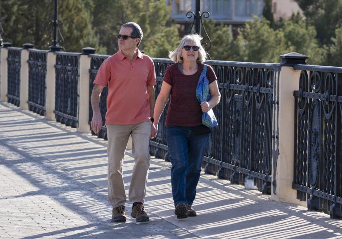 Dos personas caminan en manga corta por Teruel.