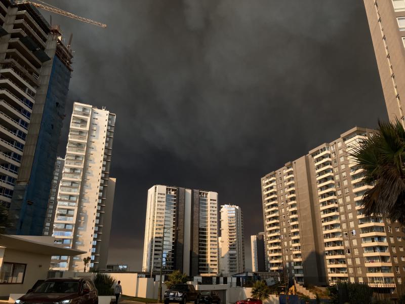 Nubarrones negros emergen sobre las rascacielos de Valparaíso por el fuego.