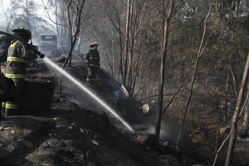 Bomberos y voluntarios tratan de extinguir los focos de un incendio en la zona de Patagual, en Viña del Mar.