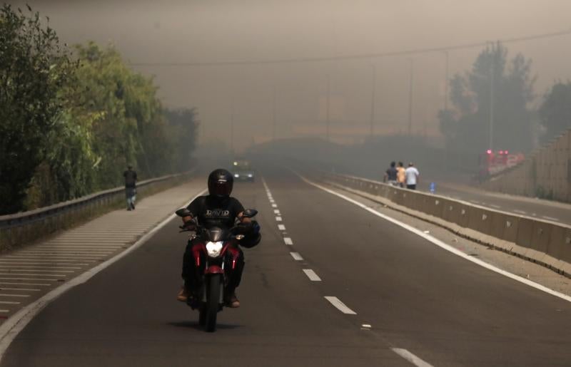 El humo de los incendios forestales reduce la visibilidad en una carretera de Las Palmas, Valparaíso.