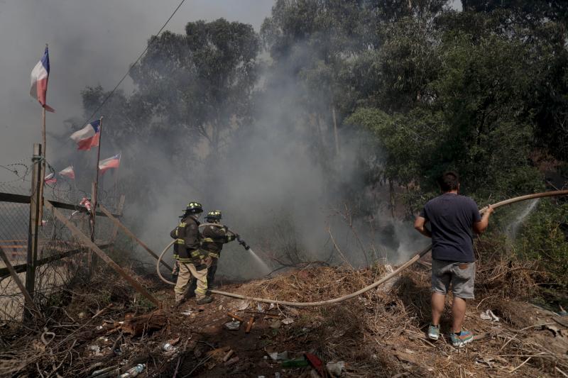 Un voluntario combate el fuego junto a bomberos en la zona de Las Palmas, Viña del Mar.