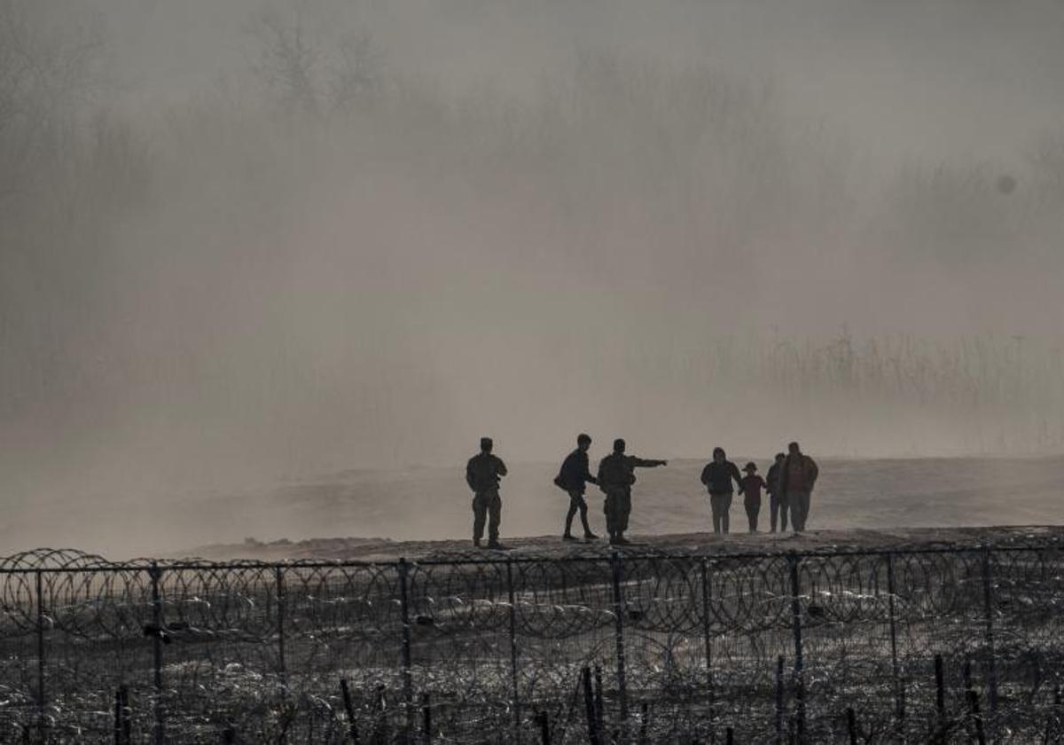 Un grupo de migrantes es detenido por miembros de la Guardia Nacional de Estados Unidos en Eagle Pass, Texas.